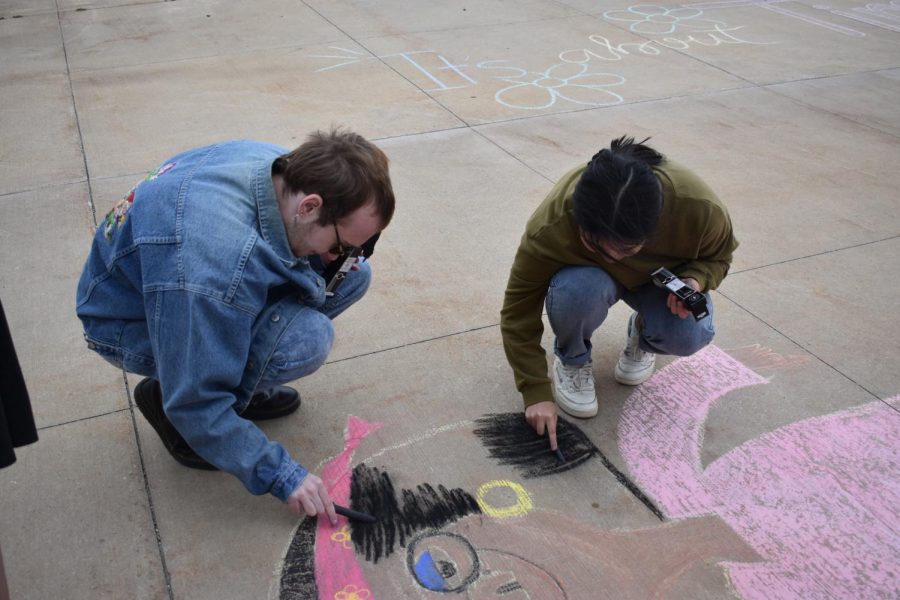Students in National Art Honor Society (NAHS) create chalk drawings outside of school. 