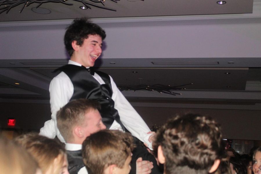 Issac Bloomgarden, junior, rests on the shoulders of his peers during prom. 