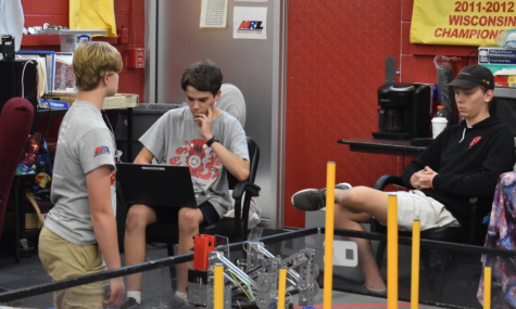 Jett Boettcher, Corey Hurda, juniors, and Adam Aufderheide, senior, members of Kraken Pinion, work to program their new robot for the challenge. 
