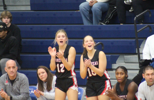 Katelyn Odem, junior, and Sam Wolf, senior, cheer on their teammates from the sidelines. Wolf attributed the team's most critical factor of success to true commitment and effort. “Each girl on our team cares about the team's success and not just their own goals. No player is selfish.”