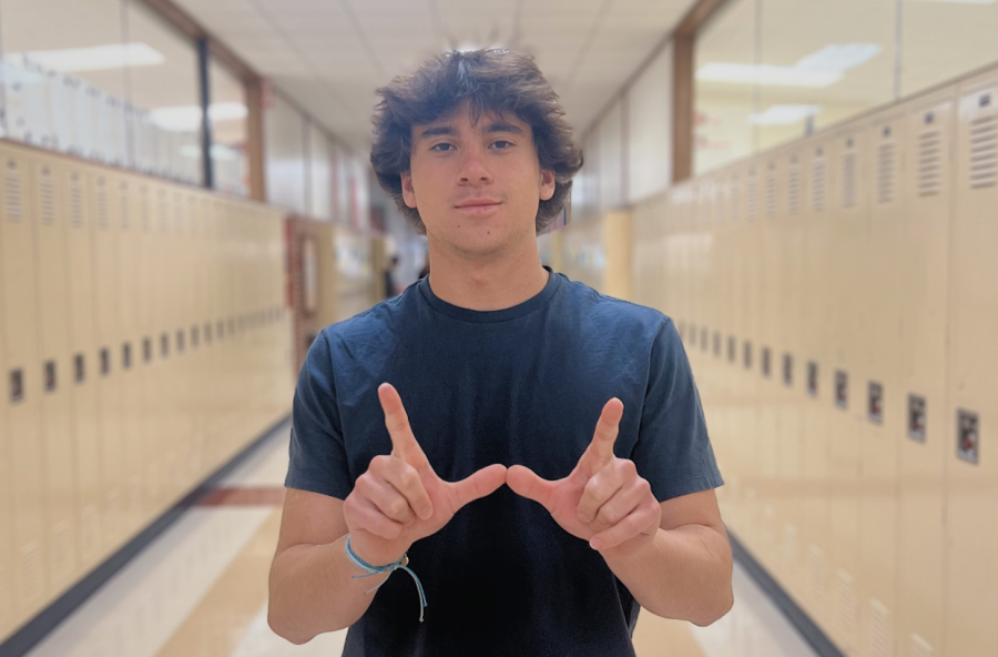 Jack Gruen holds up a W, indicating his commitment to UW Madison.