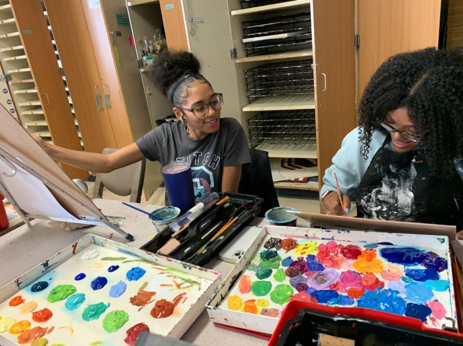Jamila Washington and Karissa Bonds, juniors, bond over their paintings.