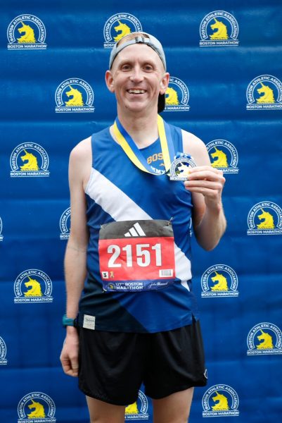 Band teacher, Charlie OBrien, poses with his medal after completing the Boston Marathon. 