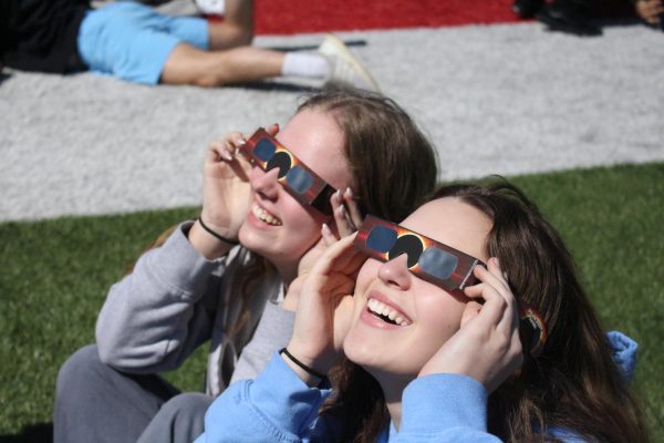 Staff and students watch the solar eclipse out on the football field during their fifth hour. 