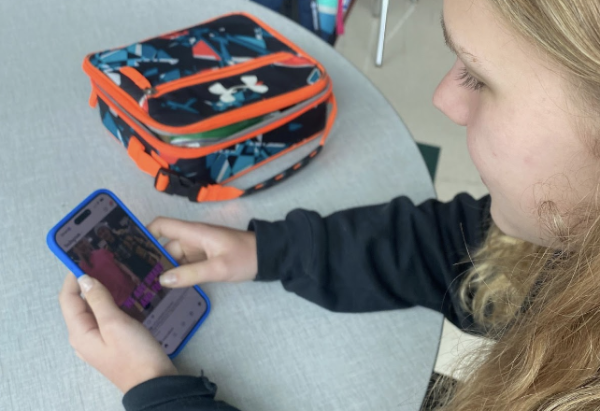 Anya Mihailenko, sophomore, scrolls on her phone during lunch. 