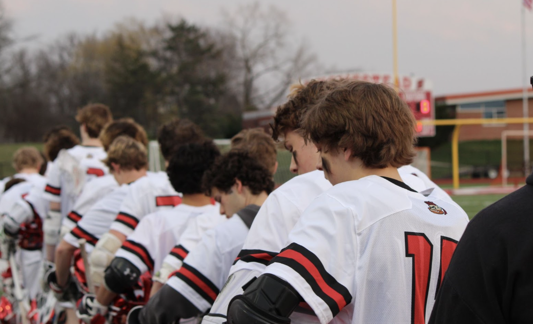 The+boys+lacrosse+team+lines+up+for+the+national+anthem+before+the+game+begins.
