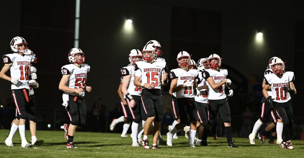 The football teams runs out to meet conference opponent Nicolet.