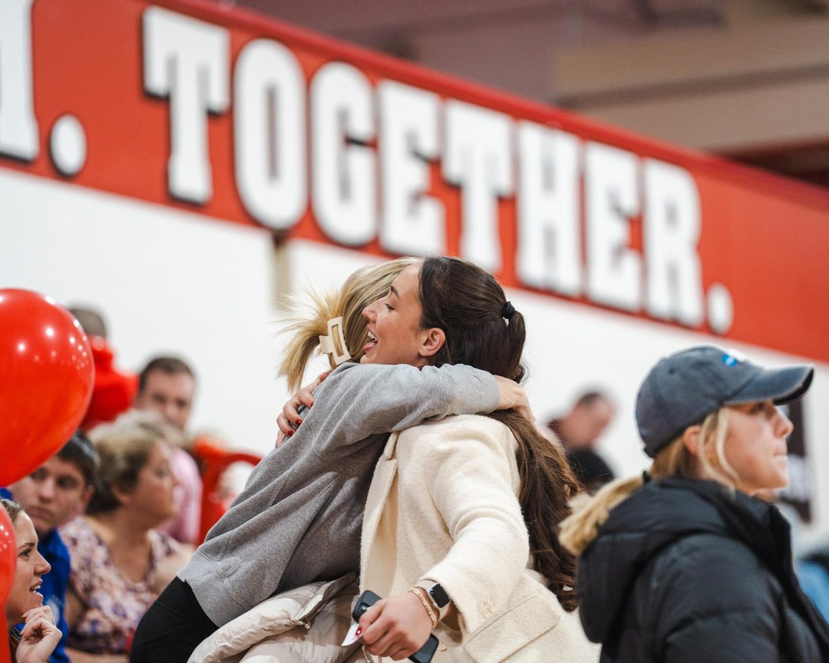 Chloe Marotta, Class of ‘18, hugs a friend in the stands at the game. Marotta connected with other alumnae in order to get as many people in attendance at the Girls Basketball Alumnae Game. “It is good for people to just come to the game and see these girls play,” Marotta said. 