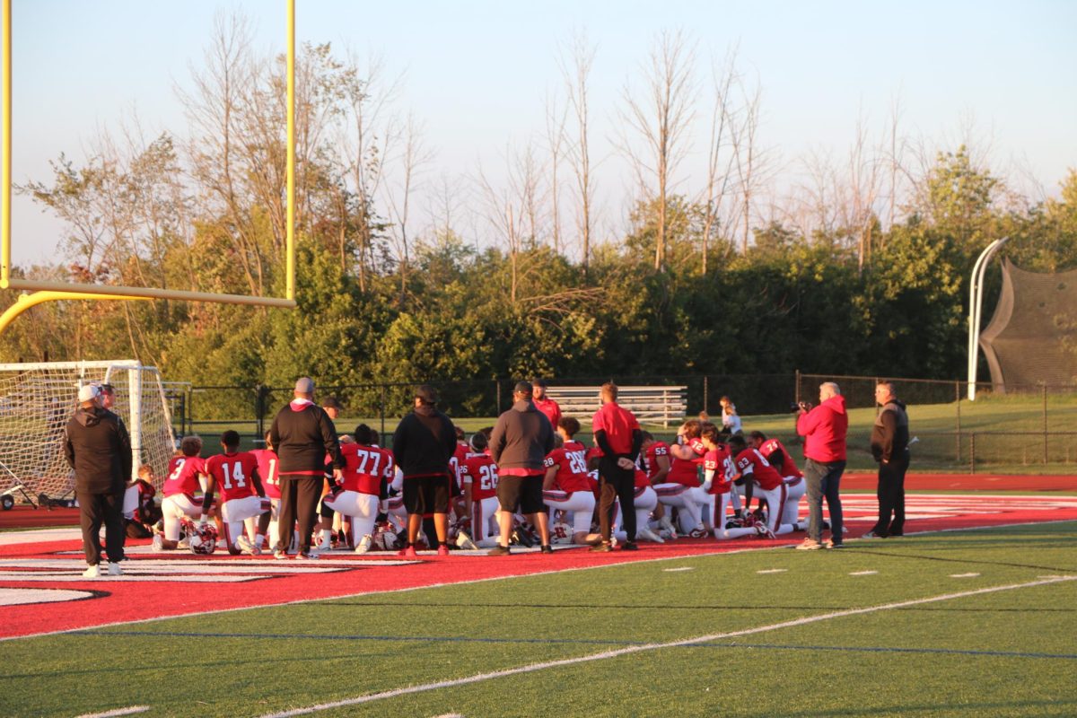 The football team takes a knee as they prepare for the upcoming game against Nicolet.
