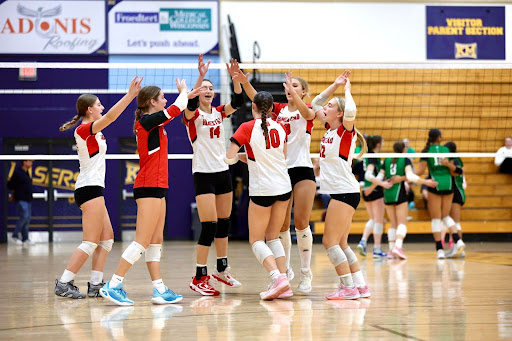 Reese Lalonde, Lauren Fitzgibben, Jessie Knoblock, Anya Mikhailenko, Kennedy Klueger, and Nyla Steltz cheer after winning a point at the Kettle Moraine tournament