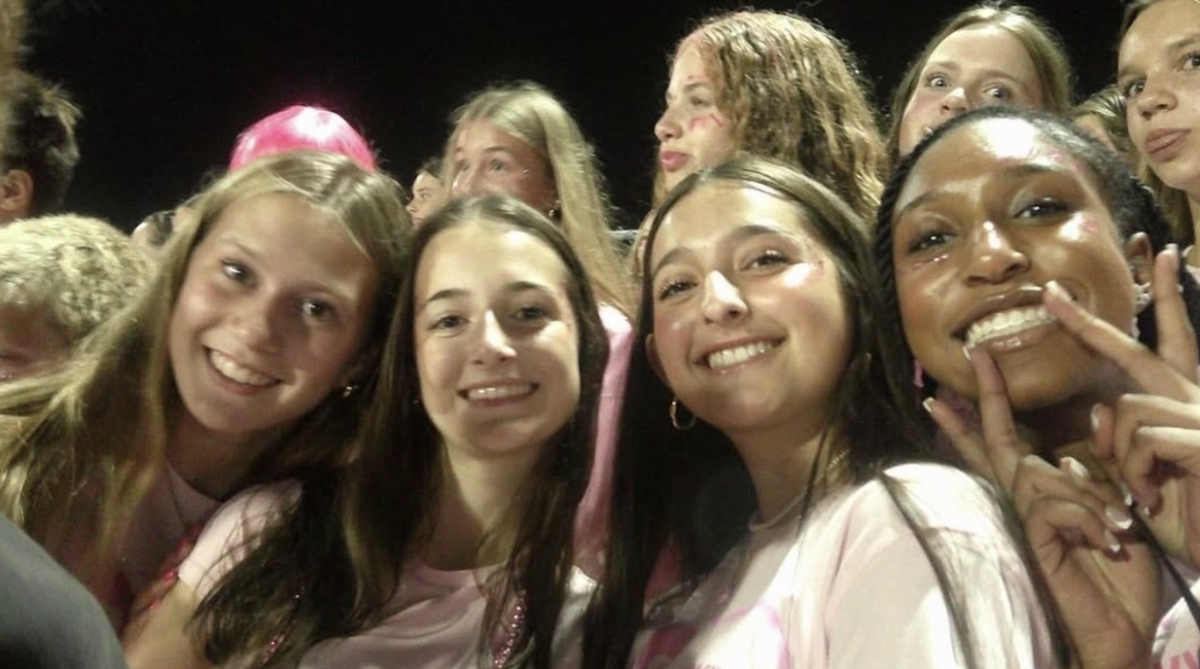 Milana Grigoryan smiles with Sienna Bott, Everly Rech, and Aira Harris at a Homestead football game
